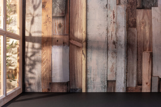 Panorama de fond d'un mur en planches en bois avec une fenêtre pour création d'arrière plan. Jeu d'ombre et de lumière du soleil à travers une fenêtre avec des branches d'oliviers.	