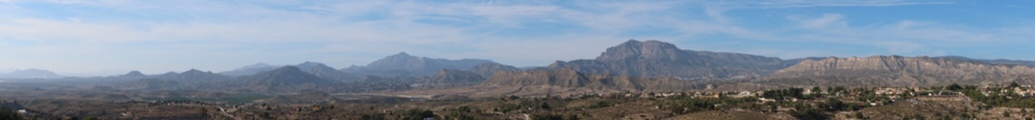 Fototapeta na wymiar Busot, Alicante, Spain, January 28, 2024: Panoramic of the multiple mountain ranges seen from Busot, Alicante, Spain