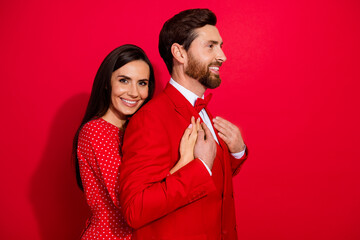 Profile photo of two cheerful peaceful partners cuddle look empty space isolated on red color background