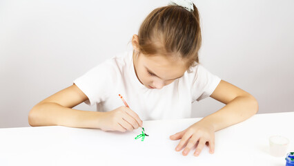 Naklejka premium Paint painting school, A preteen girl with paints and brushes on an isolated white background. Development of children's creativity.