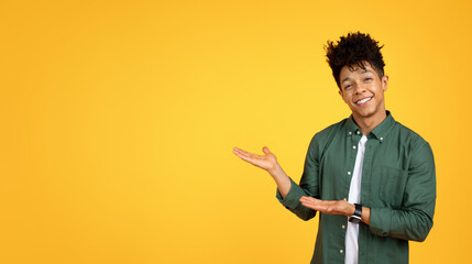 Smiling millennial black man showing blank copy space