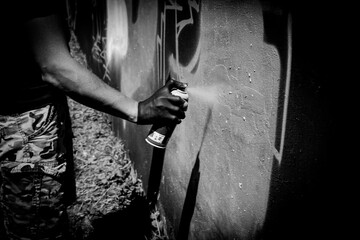 Painting graffiti. Black and white photo. Graffiti artist. 