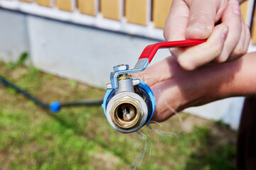 Using flexible HDPE pipe for watering garden, metal ball valve with lever is attached to end of...