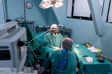 Skilled surgeon performs a precise operation in a sterile operating room.	