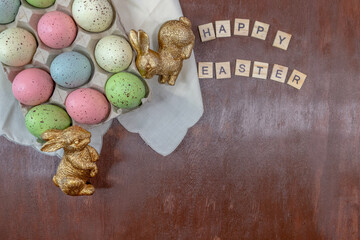 easter eggs and bunnies  with Happy Easter lettering on wood background flatlay