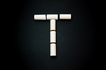 Der Buchstabe T aus kleinen Rollen geformt.