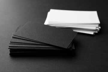 Many business cards on black background, closeup. Mockup for design