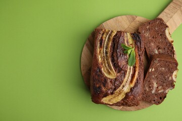 Delicious banana bread with mint on green background, top view