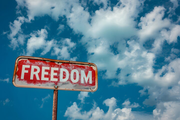 Fototapeta premium Verwitterte Freiheit: Heruntergekommenes Schild mit der Aufschrift 'FREEDOM' verströmt nostalgische Authentizität und erzählt Geschichten vergangener Zeiten auf verlassenem Gelände.