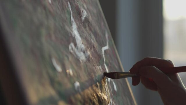 A sophisticated and impressive world of art in the hands of talented artist. The woman creates and reveals her own imaginary world, transfers it to the canvas with each movement of the brush at sunset