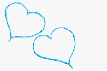 Heart made of thin twisted blue paper cut out on a light background