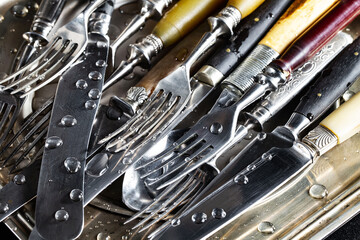 Fototapeta premium Antique silver cutlery on a dark background in a composition on a table.
