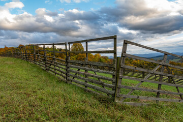 A wooden fence in the countryside, delimiting arable land and protecting it from wild animals.