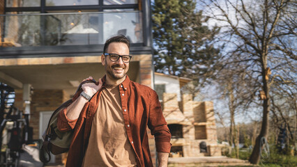 Naklejka premium Portrait of one man happy caucasian male with travel bag at his house