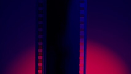 Vertical strip of blank film on a blue background with a red circular light close up. Processing negatives. Copy space.