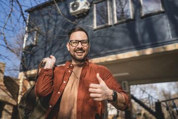 Portrait of one man happy caucasian male with travel bag at his house