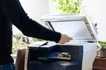 A man is using a copier. A man scans or copies documents on a copy machine. Working with a scanner...