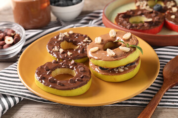Fresh apples with nut butters, peanuts and chocolate chips on table