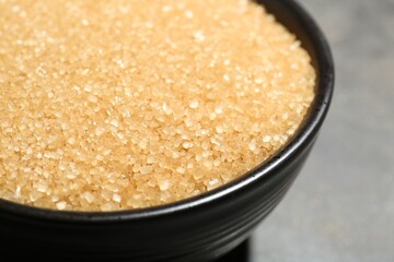 Brown sugar in bowl on blurred background, closeup