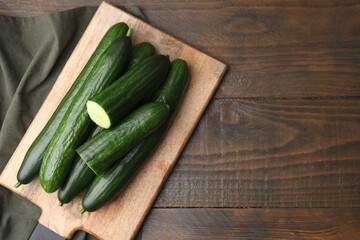 Fresh cucumbers on wooden table, top view. Space for text