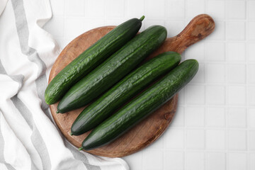 Fresh cucumbers on white tiled table, top view