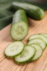 Cut ripe cucumber on wooden board, closeup