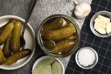 Tasty pickled cucumbers and spices on table, flat lay