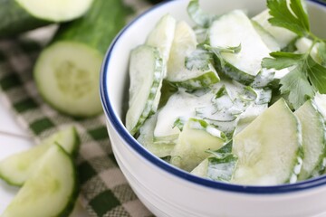 Delicious cucumber salad in bowl on table, closeup. Space for text