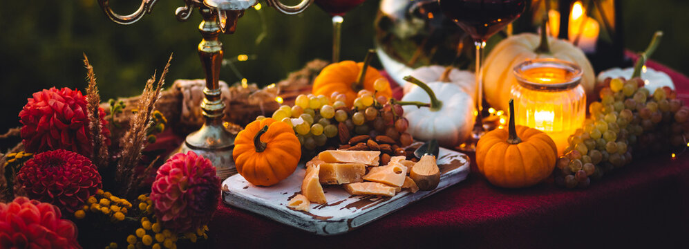 Fall Table Decoration With Pumpkins, Wine. Family Thanksgiving Dinner Arrangement Outdoors In The Garden. Countryside Style, Simple Handmade Setting, Autumn Mood Banner