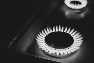 a hundred dollar bill on a gas burner with a burning fire on a black background, the front and back...