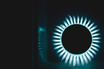 a hundred dollar bill on a gas burner with a burning fire on a black background, the front and back background is blurred with a bokeh effect