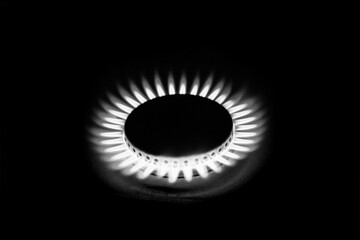 a hundred dollar bill on a gas burner with a burning fire on a black background, the front and back background is blurred with a bokeh effect