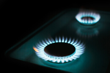 a hundred dollar bill on a gas burner with a burning fire on a black background, the front and back...