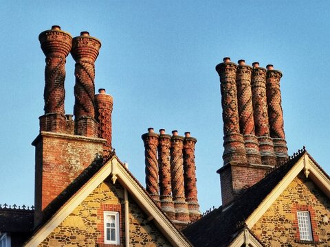 Elizabethan chimney stacks stand tall above a house in Albury, Surrey, UK 
