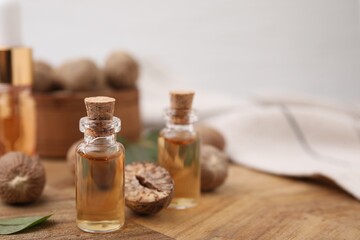 Nutmeg essential oil and nuts on table. Space for text