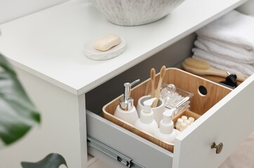 Different bath accessories and personal care products in drawer indoors