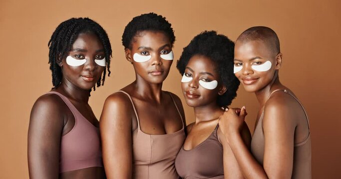 Happy black woman, eye patches and skincare for beauty, cosmetics or anti aging on a brown studio background. Group portrait of African female people or model in dermatology, health and wellness