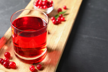Tasty refreshing cranberry juice and fresh berries on grey textured table. Space for text