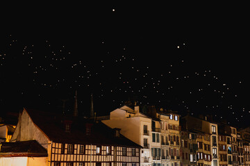 Nighttime cityscape with illuminated windows and starry sky