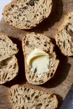 Artisan bread slices with butter on wooden board