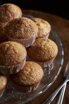 Homemade golden brown muffins on glass stand