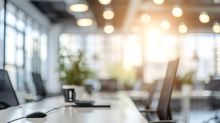 A modern office space blurred background with natural light with a focus on a natural green plant, space for text