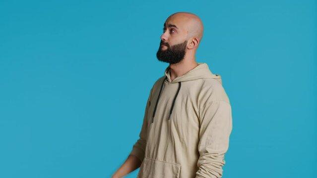 Arab man exploring artificial intelligence with holograms, examining holographic projection of a slideshow in studio. Middle eastern person looks at graphic image on holograph. Camera 1.