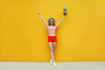 Summer cheerful young woman having fun holding pineapple