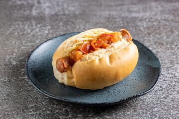 Homemade hot dog with grilled sausage, tomato sauce and straw potatoes.