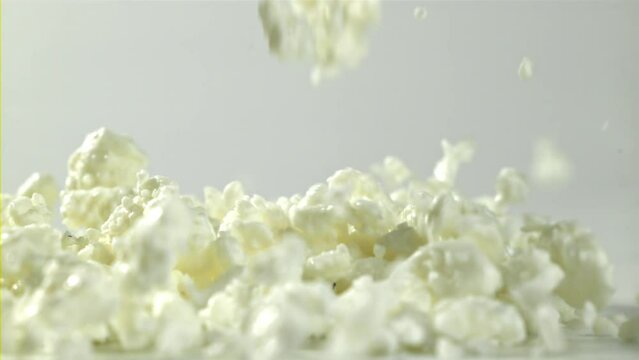 Fresh cottage cheese falling on white background. Filmed on a high-speed camera at 1000 fps. High quality FullHD footage