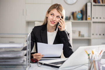 Office woman is discussing the contract by phone in the office