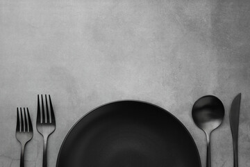 Clean plate and cutlery on grey table, flat lay. Space for text