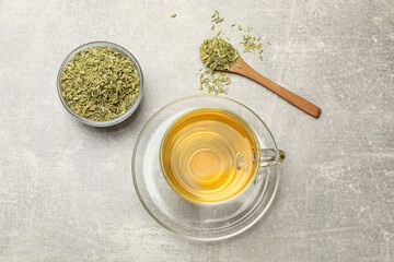 Obraz na płótnie Canvas Aromatic fennel tea and seeds on light grey table, flat lay