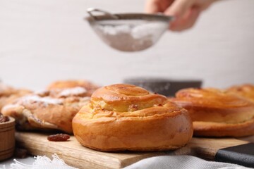 Delicious rolls with raisins on table, closeup. Sweet buns